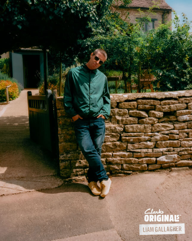 Liam Gallagher x Clarks Originals. Liam Gallagher stands wearing Clarks Originals Desert Rain Limited Edition Shoes